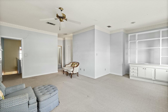 carpeted living room featuring ornamental molding and ceiling fan