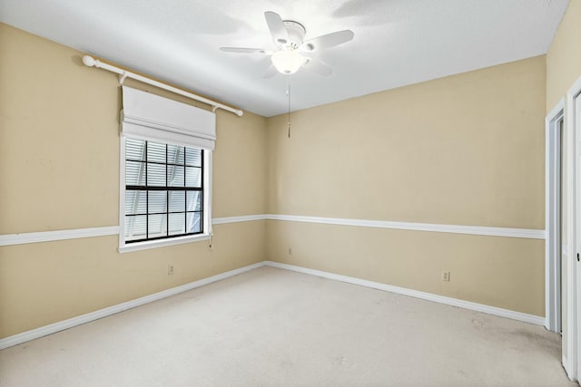 carpeted spare room featuring ceiling fan