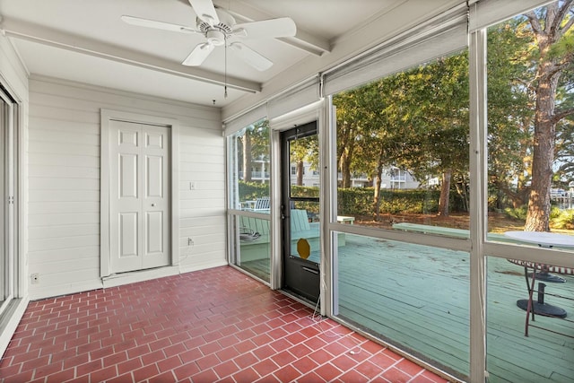 unfurnished sunroom featuring ceiling fan