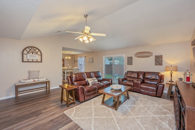 living room featuring hardwood / wood-style flooring, vaulted ceiling, and ceiling fan with notable chandelier