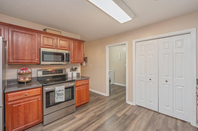 kitchen with dark hardwood / wood-style flooring, stainless steel appliances, and a textured ceiling