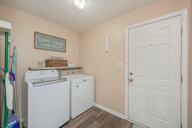 laundry area with dark hardwood / wood-style flooring, washing machine and dryer, and a textured ceiling