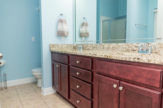 bathroom with vanity, tile patterned floors, toilet, and walk in shower