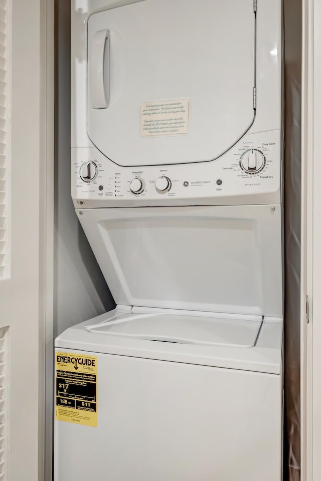 clothes washing area with stacked washer / dryer