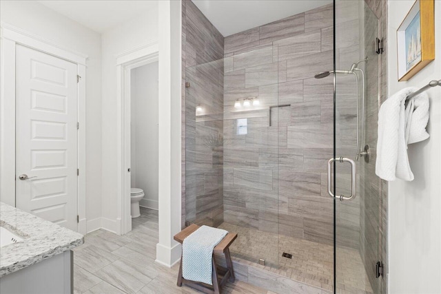 bathroom with vanity, toilet, and an enclosed shower