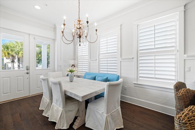 dining space featuring crown molding, dark wood-type flooring, and a chandelier