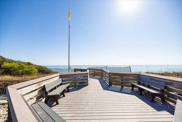 view of dock featuring a deck with water view and a view of the beach