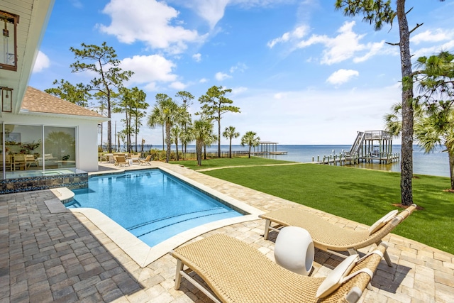 view of pool with a patio, a water view, a yard, and an in ground hot tub