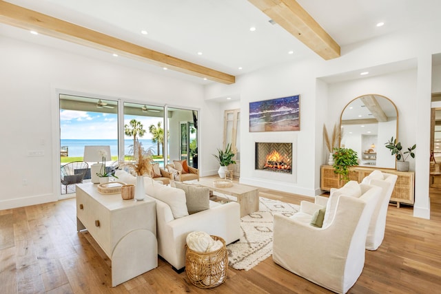 living room featuring a water view, beam ceiling, and light hardwood / wood-style floors