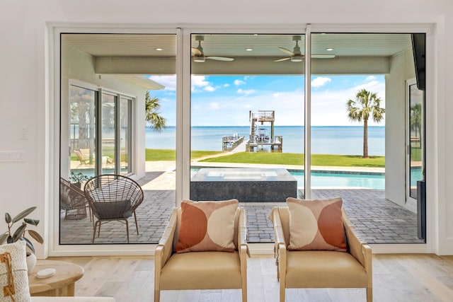 entryway featuring a water view, a healthy amount of sunlight, and light wood-type flooring