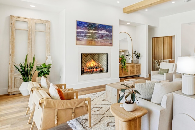 living room with beam ceiling and light hardwood / wood-style flooring