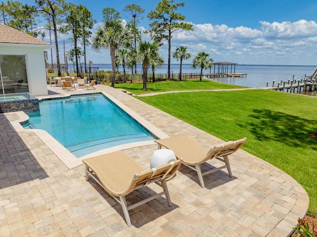 view of pool with a patio, a water view, and a yard