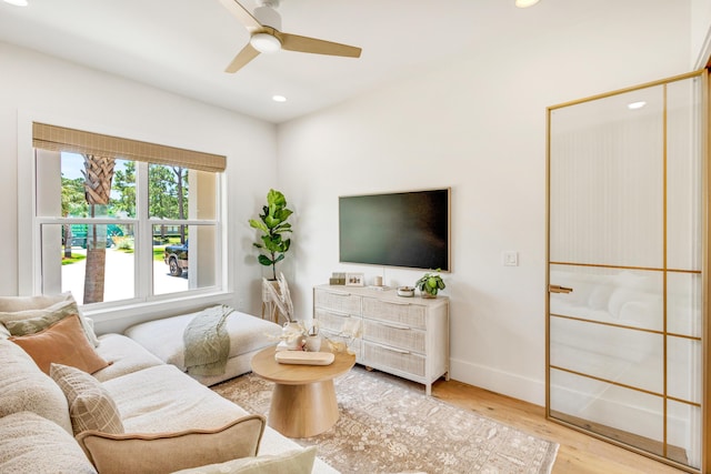 living room with ceiling fan and light hardwood / wood-style floors