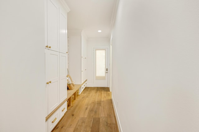 hall with crown molding and light wood-type flooring