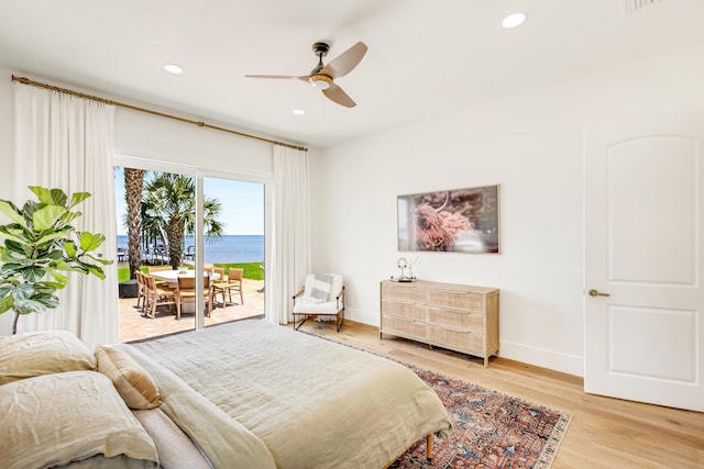 bedroom with a water view, access to outside, ceiling fan, and light hardwood / wood-style flooring