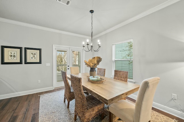 dining space with ornamental molding, dark hardwood / wood-style flooring, a chandelier, and french doors