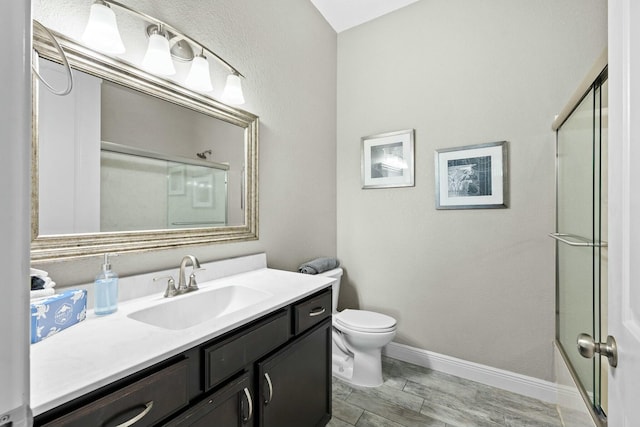 full bathroom featuring vanity, combined bath / shower with glass door, and toilet