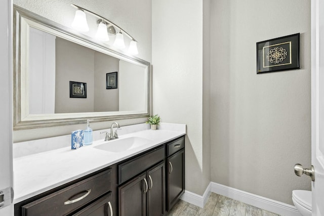 bathroom with vanity, wood-type flooring, and toilet