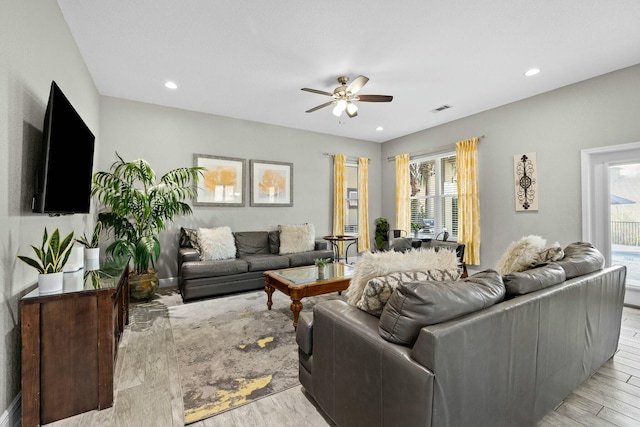 living room with ceiling fan and light wood-type flooring