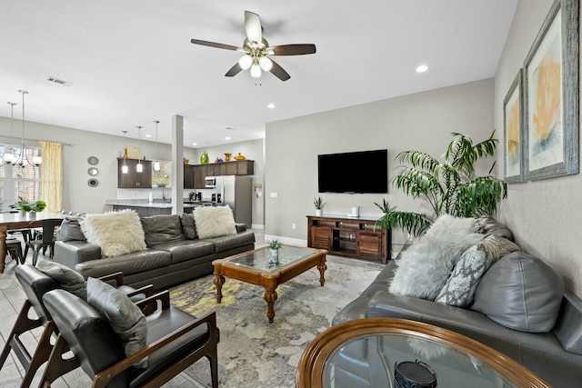 living room with ceiling fan with notable chandelier