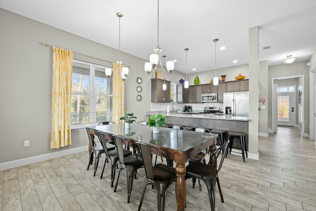 dining space with an inviting chandelier and light hardwood / wood-style floors