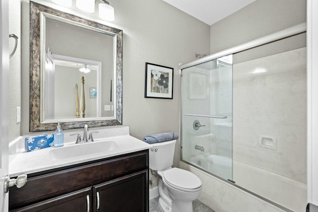 full bathroom featuring vanity, combined bath / shower with glass door, and toilet