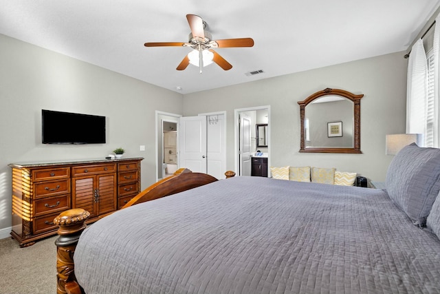 carpeted bedroom featuring ensuite bath and ceiling fan