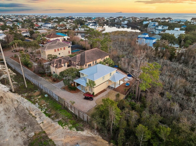 aerial view at dusk featuring a water view