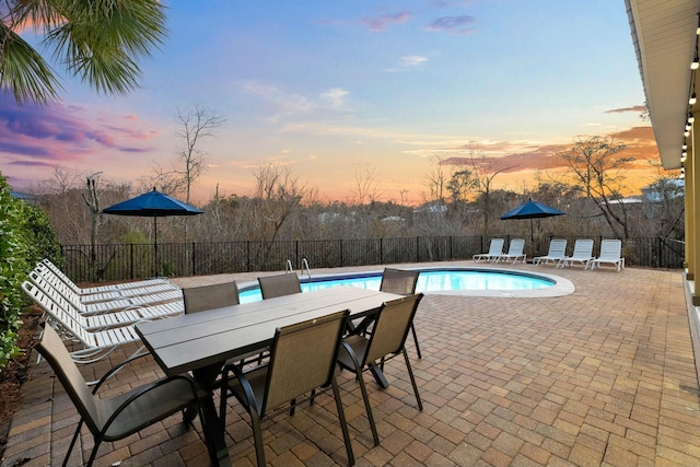 pool at dusk with a patio