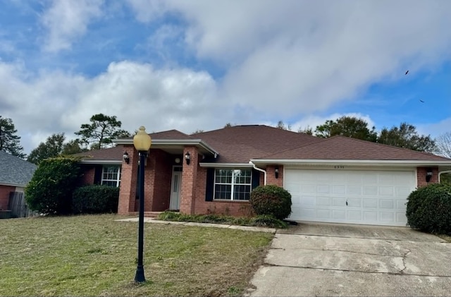 ranch-style house featuring a garage, brick siding, driveway, and a front yard