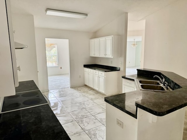 kitchen with sink, a breakfast bar, white cabinetry, vaulted ceiling, and kitchen peninsula