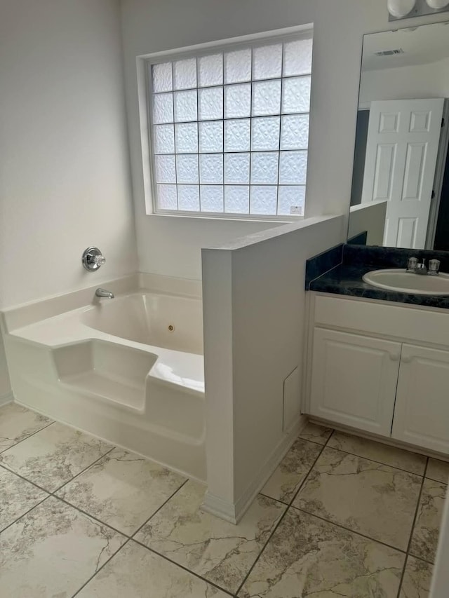 full bath with visible vents, vanity, baseboards, marble finish floor, and a whirlpool tub