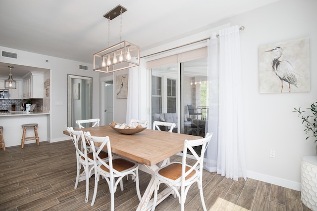 dining space featuring dark hardwood / wood-style flooring and a chandelier