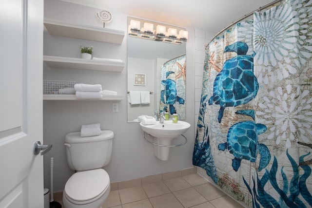 bathroom with tile patterned floors, toilet, and curtained shower