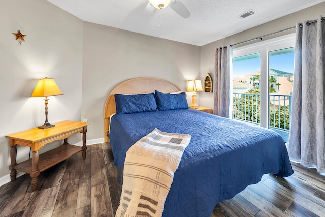 bedroom featuring dark wood-type flooring, ceiling fan, and a textured ceiling