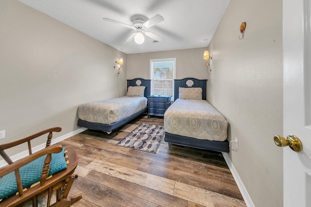 bedroom with hardwood / wood-style flooring, ceiling fan, and a textured ceiling