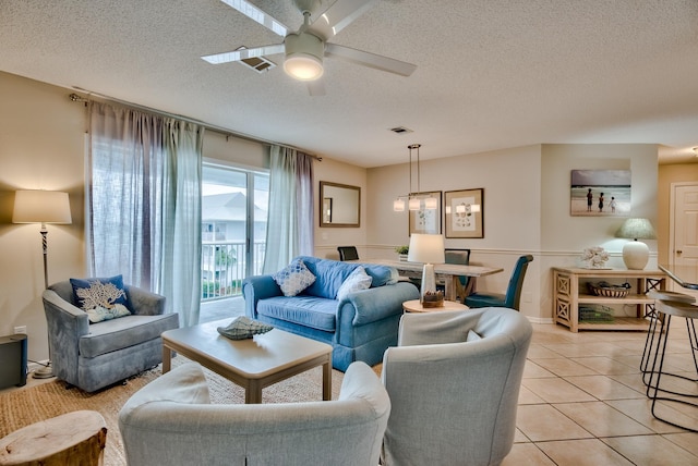 tiled living room featuring ceiling fan and a textured ceiling