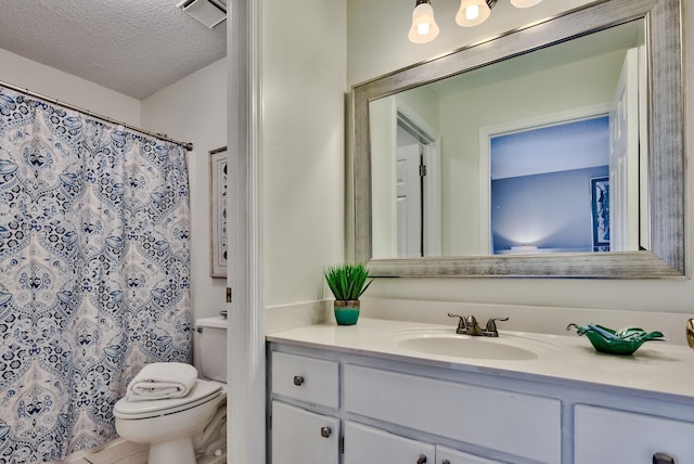 bathroom with tile patterned floors, toilet, a textured ceiling, vanity, and curtained shower