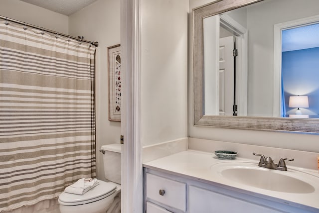 bathroom featuring vanity, toilet, and a textured ceiling