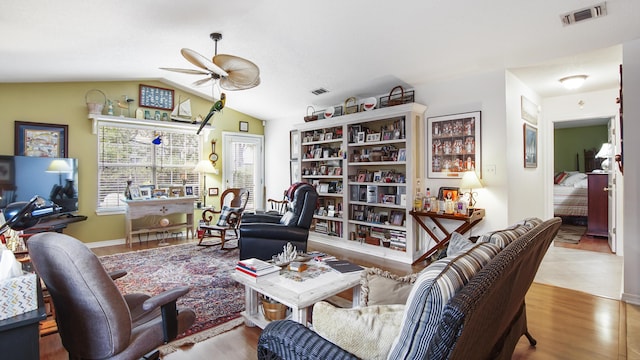 living room featuring ceiling fan, lofted ceiling, and light wood-type flooring