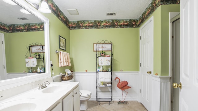 bathroom featuring vanity, tile patterned floors, a textured ceiling, and toilet