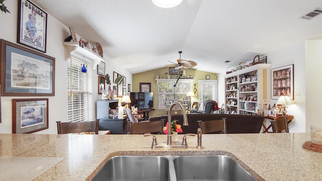 kitchen featuring vaulted ceiling, ceiling fan, plenty of natural light, and sink