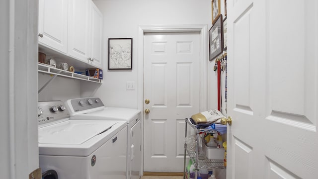 washroom with cabinets and washing machine and clothes dryer