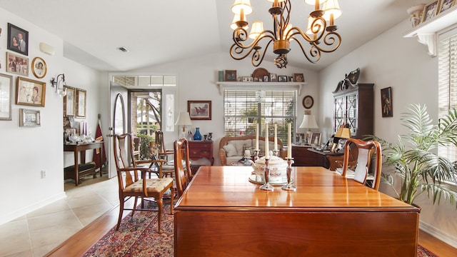 dining room with vaulted ceiling, light tile patterned floors, and a chandelier