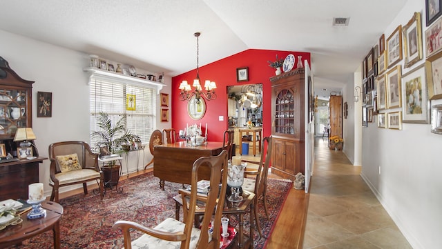 dining room featuring vaulted ceiling and a notable chandelier