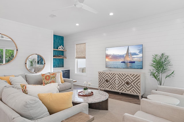 living room featuring ornamental molding, hardwood / wood-style floors, and ceiling fan