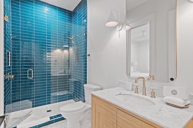 bathroom with vanity, a shower with door, and toilet