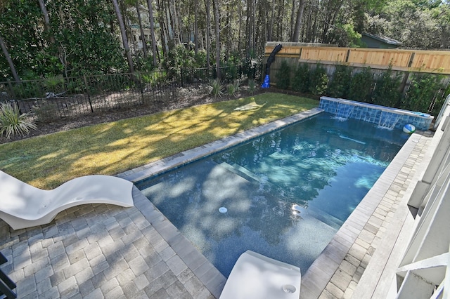 view of pool with a lawn and pool water feature