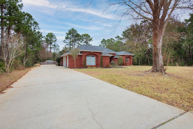 ranch-style home featuring a garage and a front lawn