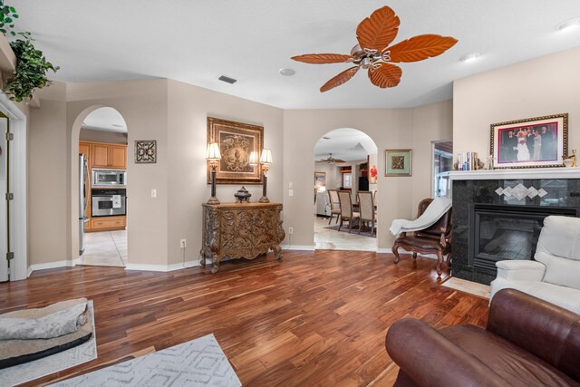 6568 Castlewood St, Navarre, FL 32566 - living room with a fireplace, ceiling fan, and light wood-type flooring